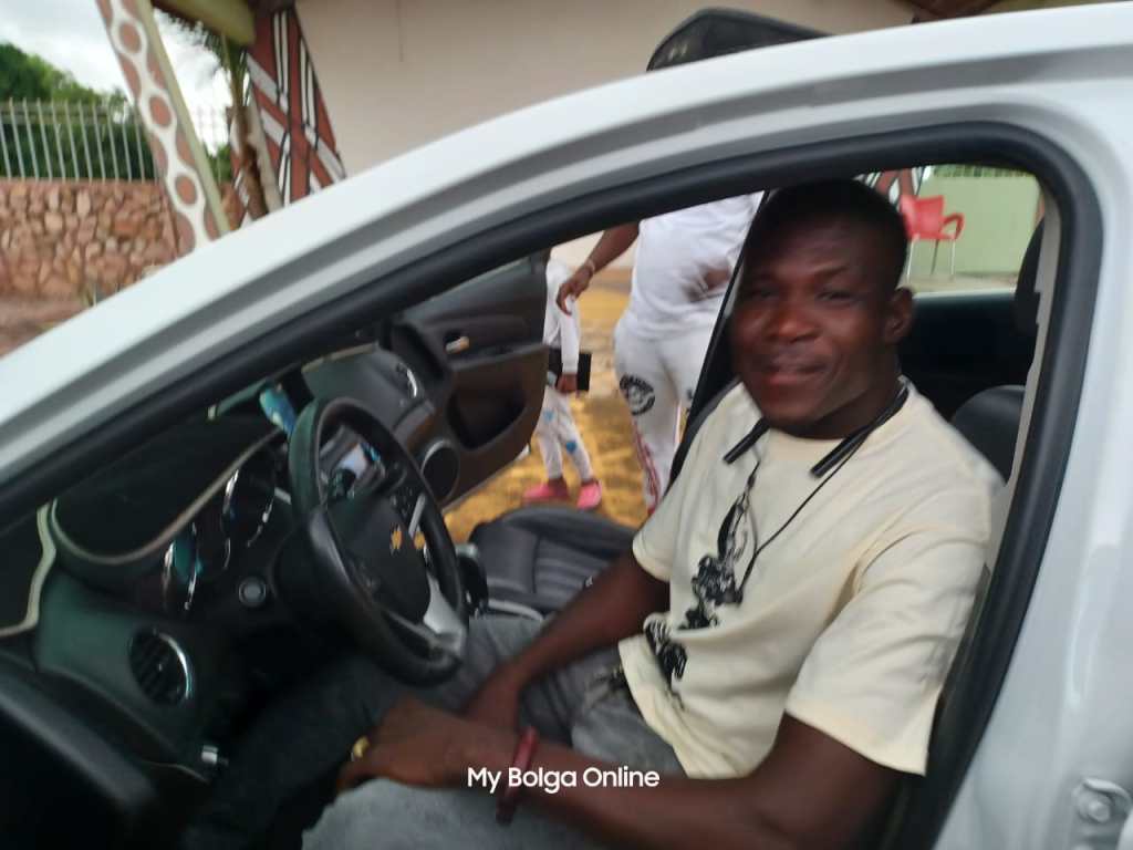 Bola Anafo sitting on his newly won car prize.